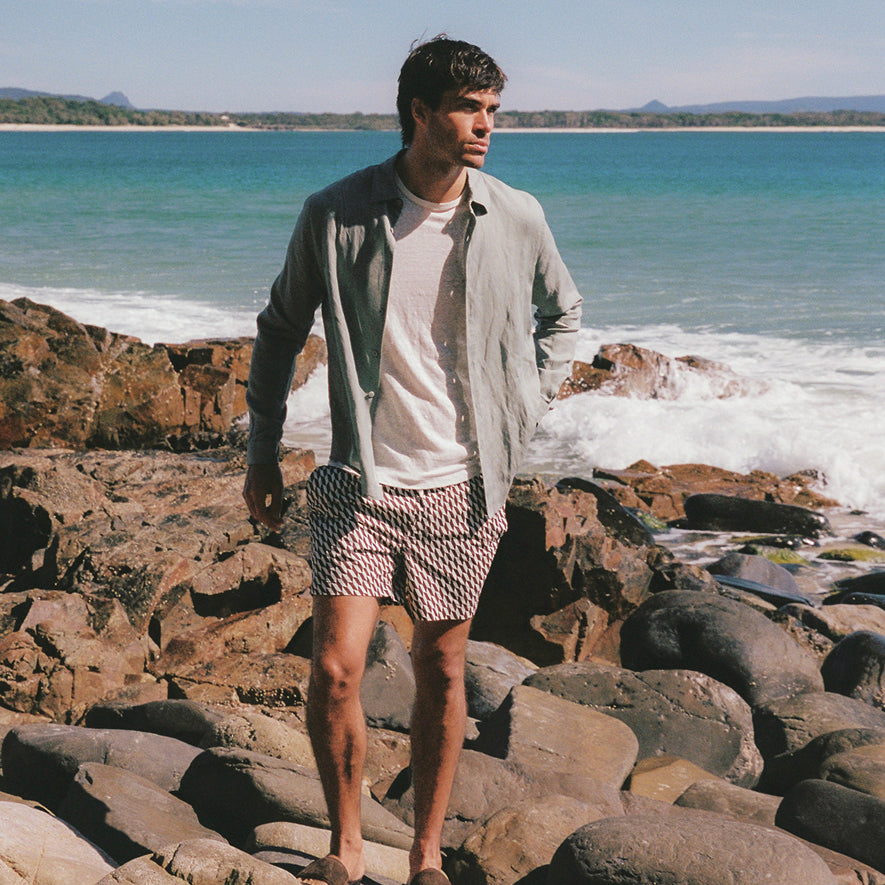 Man standing next to ocean in onia trunks
